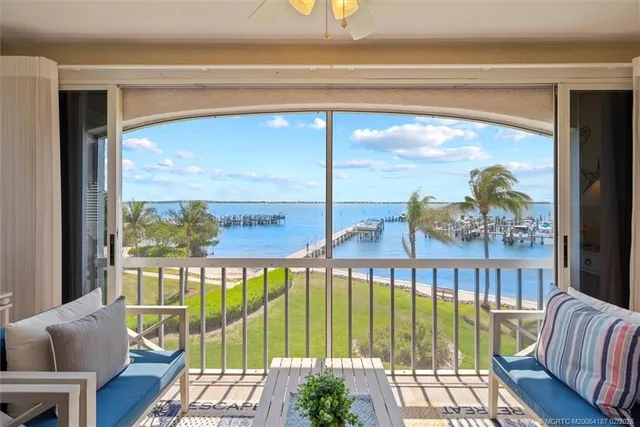 a view of a living room and floor to ceiling window in an outdoor living room