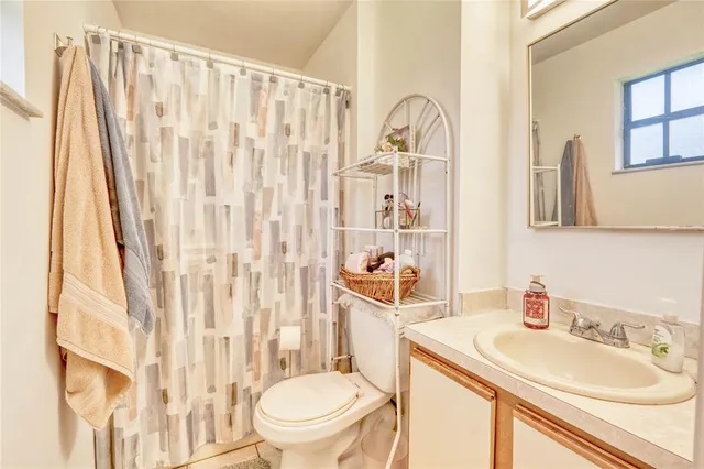 a bathroom with a sink a toilet and shower curtain