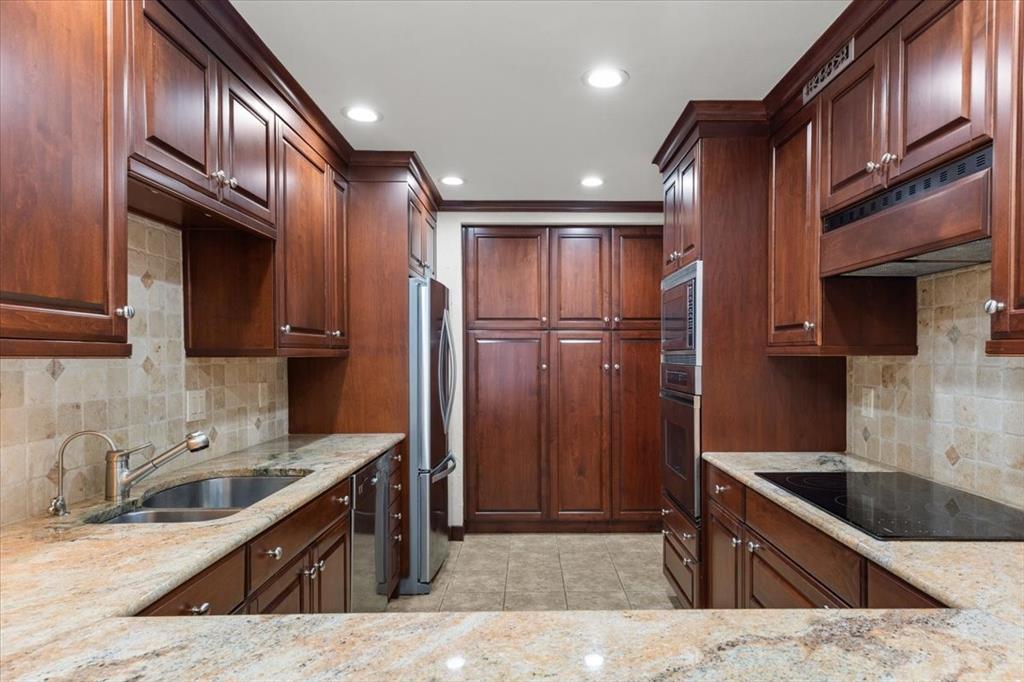 1109 Roaring Springs Road, Unit 1109 Fort Worth, TX 76114 - Photo 17 of 35 a kitchen with stainless steel appliances granite countertop a sink refrigerator and cabinets
