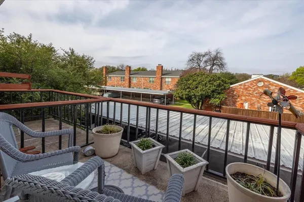 a view of a balcony with two chairs and a potted plant