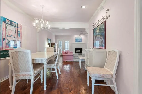 a view of a dining room with furniture a chandelier and wooden floor