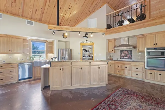 a kitchen with stainless steel appliances granite countertop a sink and a refrigerator