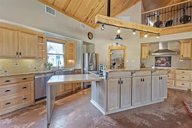 a kitchen with stainless steel appliances granite countertop a stove a sink and a white cabinets