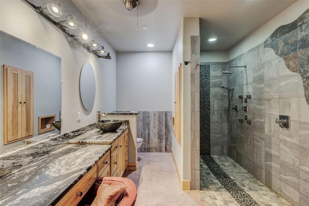 423 Hcr 1439 Covington, TX 76636 - Photo 17 of 40 a bathroom with a granite countertop sink a mirror and shower