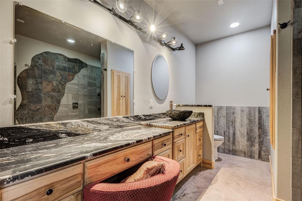 423 Hcr 1439 Covington, TX 76636 - Photo 18 of 40 a bathroom with a granite countertop sink a mirror and shower