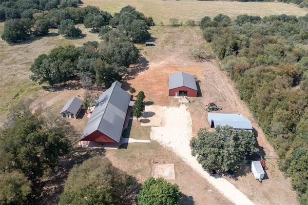 an aerial view of a house with a yard and trees