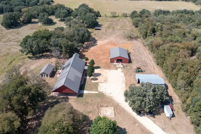 an aerial view of a house with a yard and trees