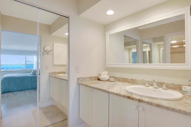 a bathroom with a granite countertop sink and a mirror