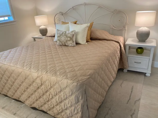 a large bed sitting in a bedroom next to a window