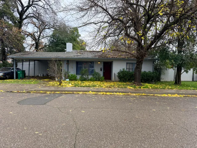 a front view of a house with a yard and palm trees