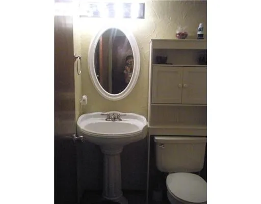 a bathroom with a sink toilet and a mirror