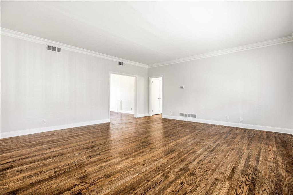 3694 Peachtree Road Northeast, Unit A4 Atlanta, GA 30319 - Photo 3 of 17 a view of an empty room with wooden floor and a window