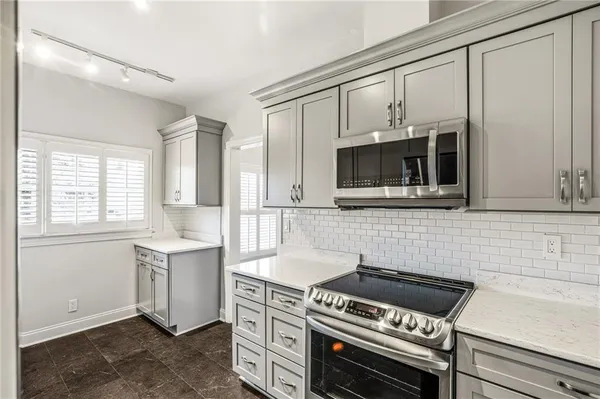 a kitchen with stainless steel appliances a stove a sink and a microwave