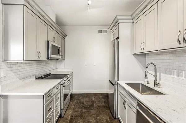 a kitchen with stainless steel appliances granite countertop a sink stove and refrigerator