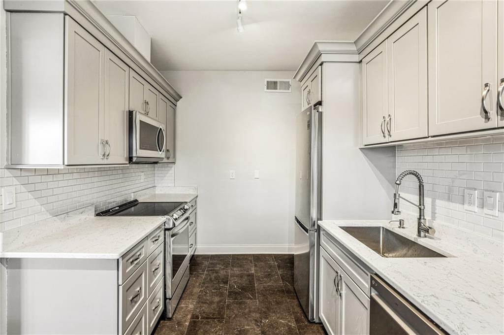 3694 Peachtree Road Northeast, Unit A4 Atlanta, GA 30319 - Photo 8 of 17 a kitchen with stainless steel appliances granite countertop a sink stove and refrigerator