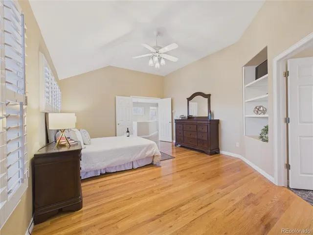 an empty room with wooden floor and a bathroom