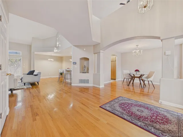 a dining room with furniture a chandelier and wooden floor