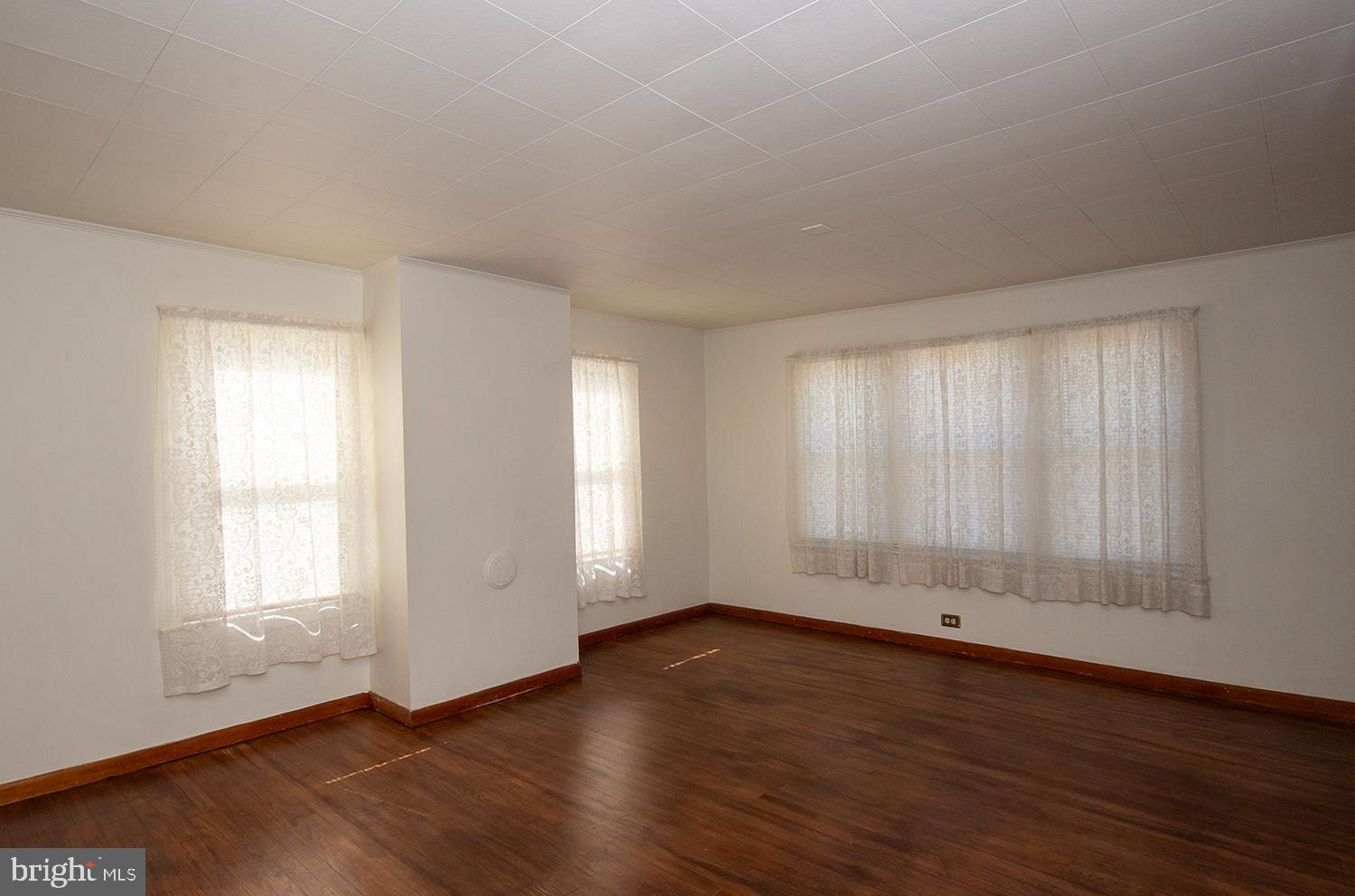 34463 Rider Road Delmar, DE 19940 - Photo 18 of 47 an empty room with wooden floor and windows with curtains view