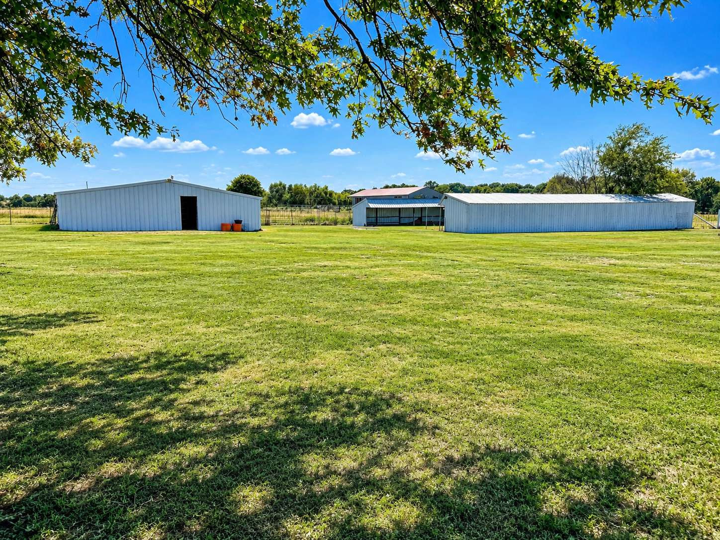 21800 East 450th Road Claremore, OK 74019 - Photo 5 of 23 Expansive grassy grounds with multiple outbuildings featuring metal siding and gable roofs