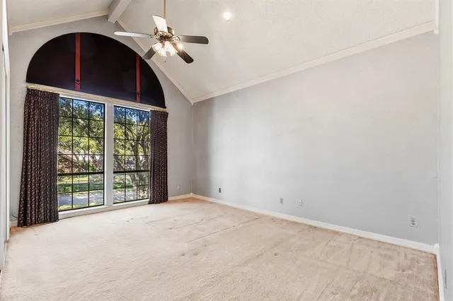an empty room with windows and ceiling fan