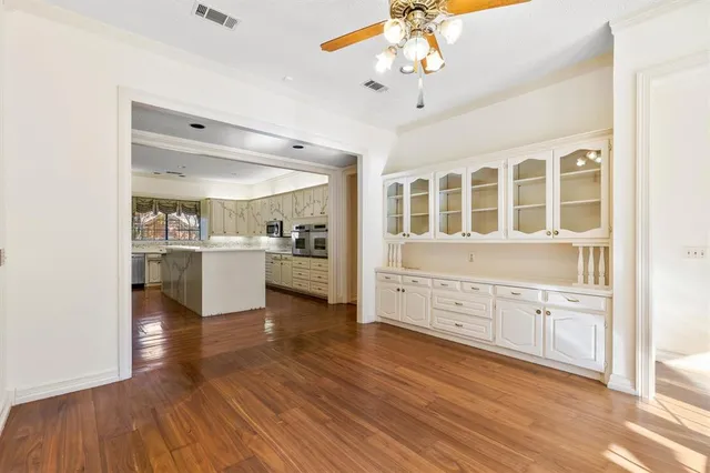 a kitchen with stainless steel appliances a stove top oven and a wooden floor