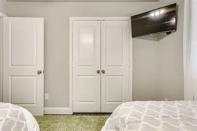 a view of bedroom with wooden floor and flat screen tv