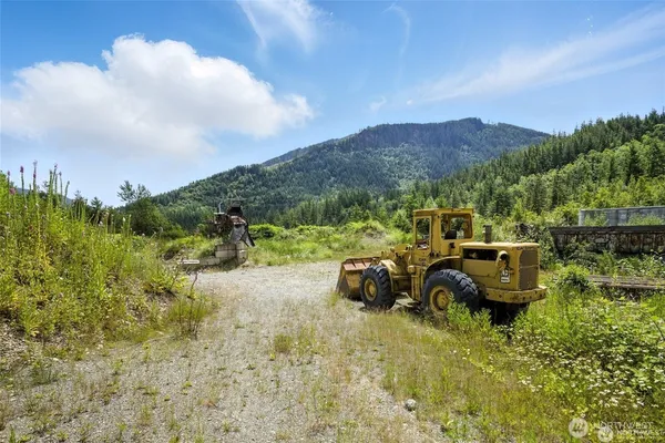 a view of a dry yard with wooden fence