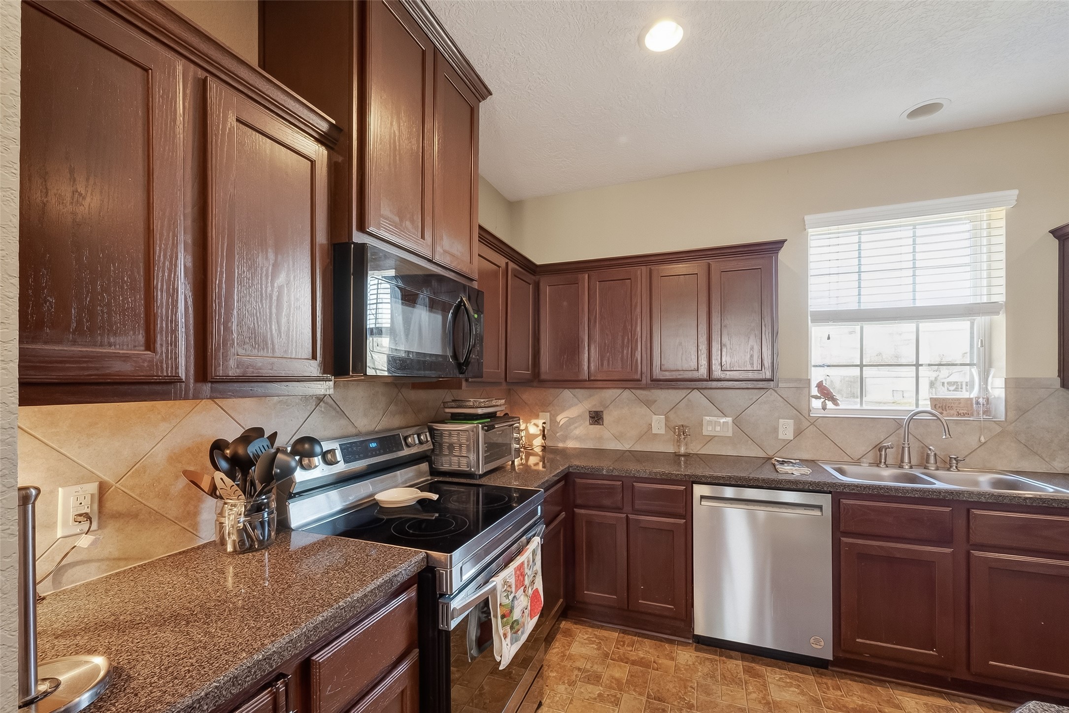 3418 Barbers Hill Road Highlands, TX 77562 - Photo 26 of 50 a kitchen with granite countertop a sink stove and cabinets