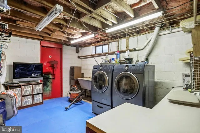 a utility room with dryer washer and a wooden floor