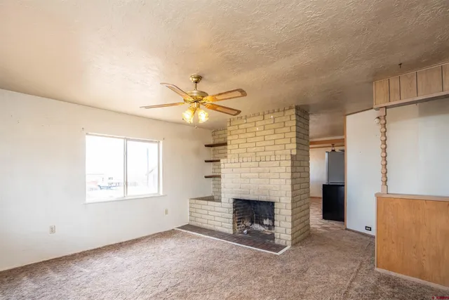 an empty room with fireplace and windows