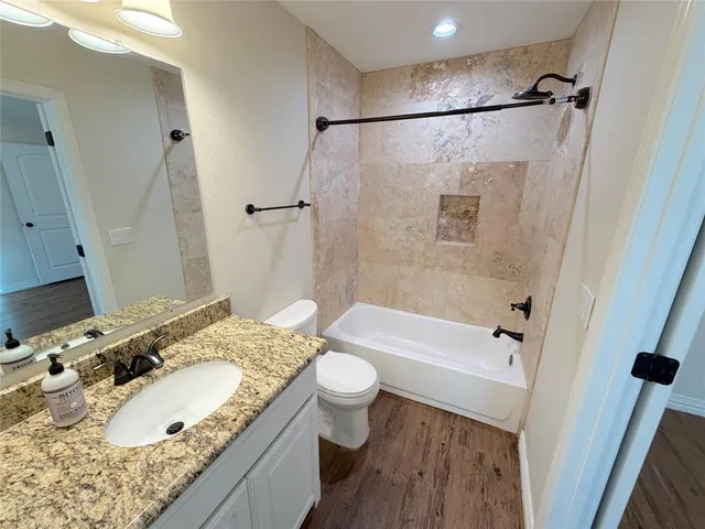 a bathroom with a granite countertop sink toilet and shower