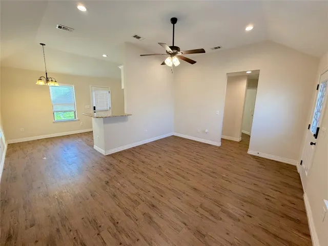 a view of empty room with wooden floor and ceiling fan
