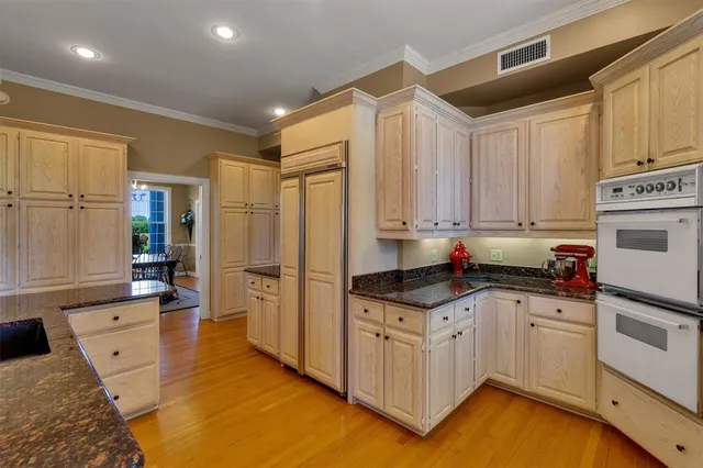 a kitchen with granite countertop a sink a counter top space stainless steel appliances and cabinets