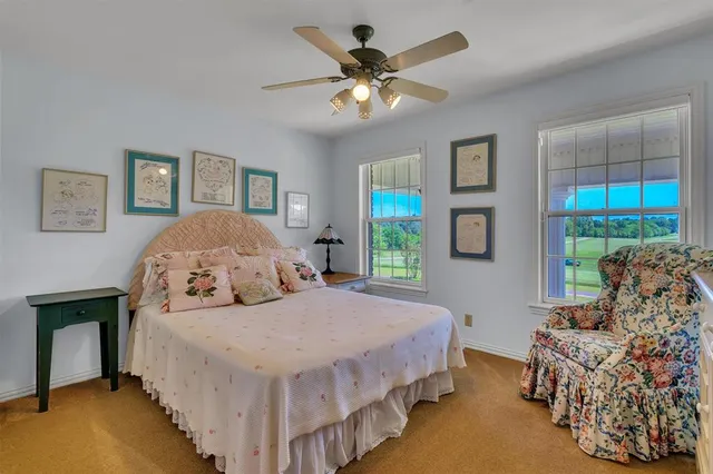 a bedroom with a bed and a lamp on dresser