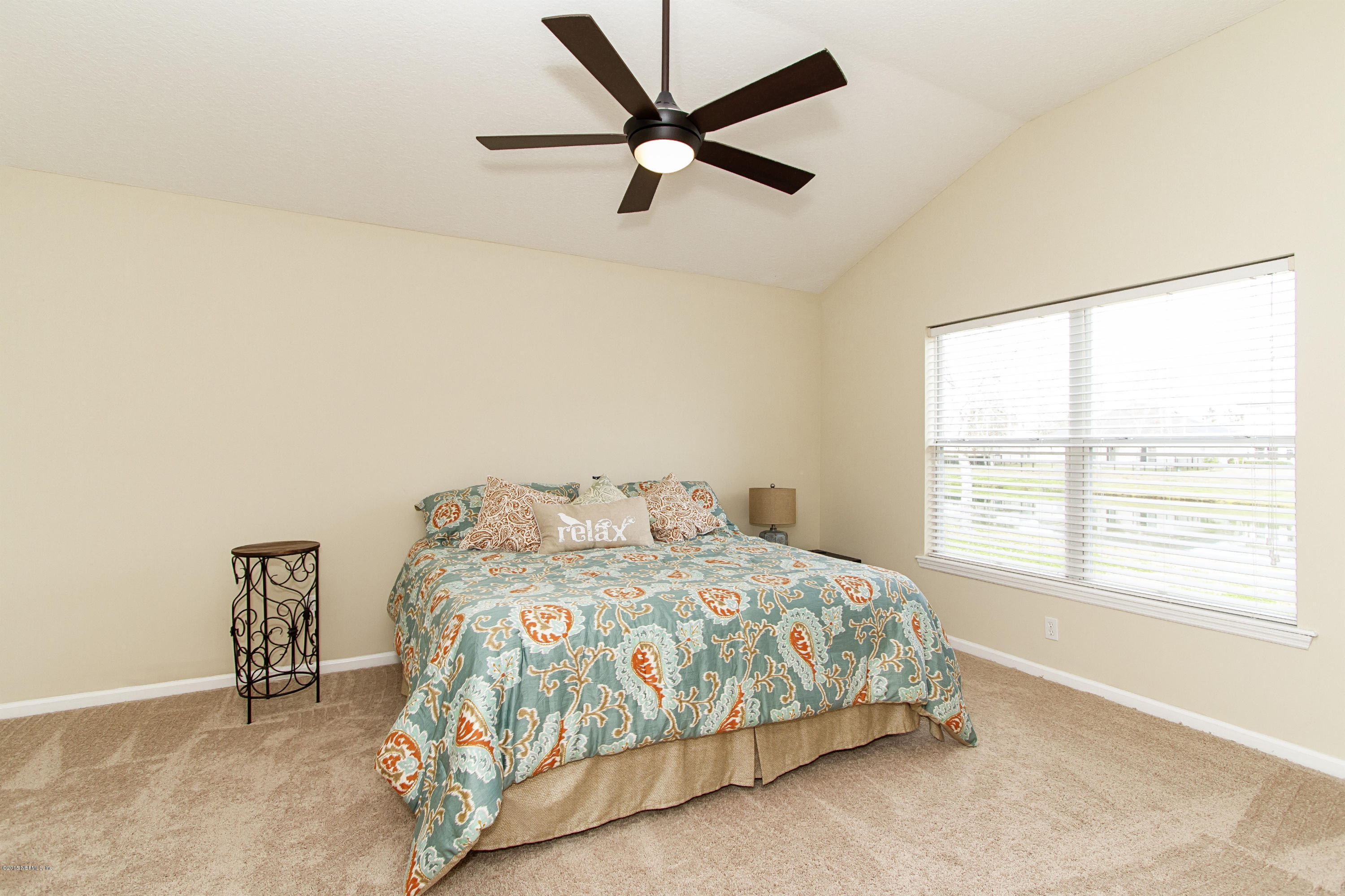 720 Porta Rosa Circle St. Augustine, FL 32092 - Photo 12 of 26 a bedroom with a bed a window and a couch