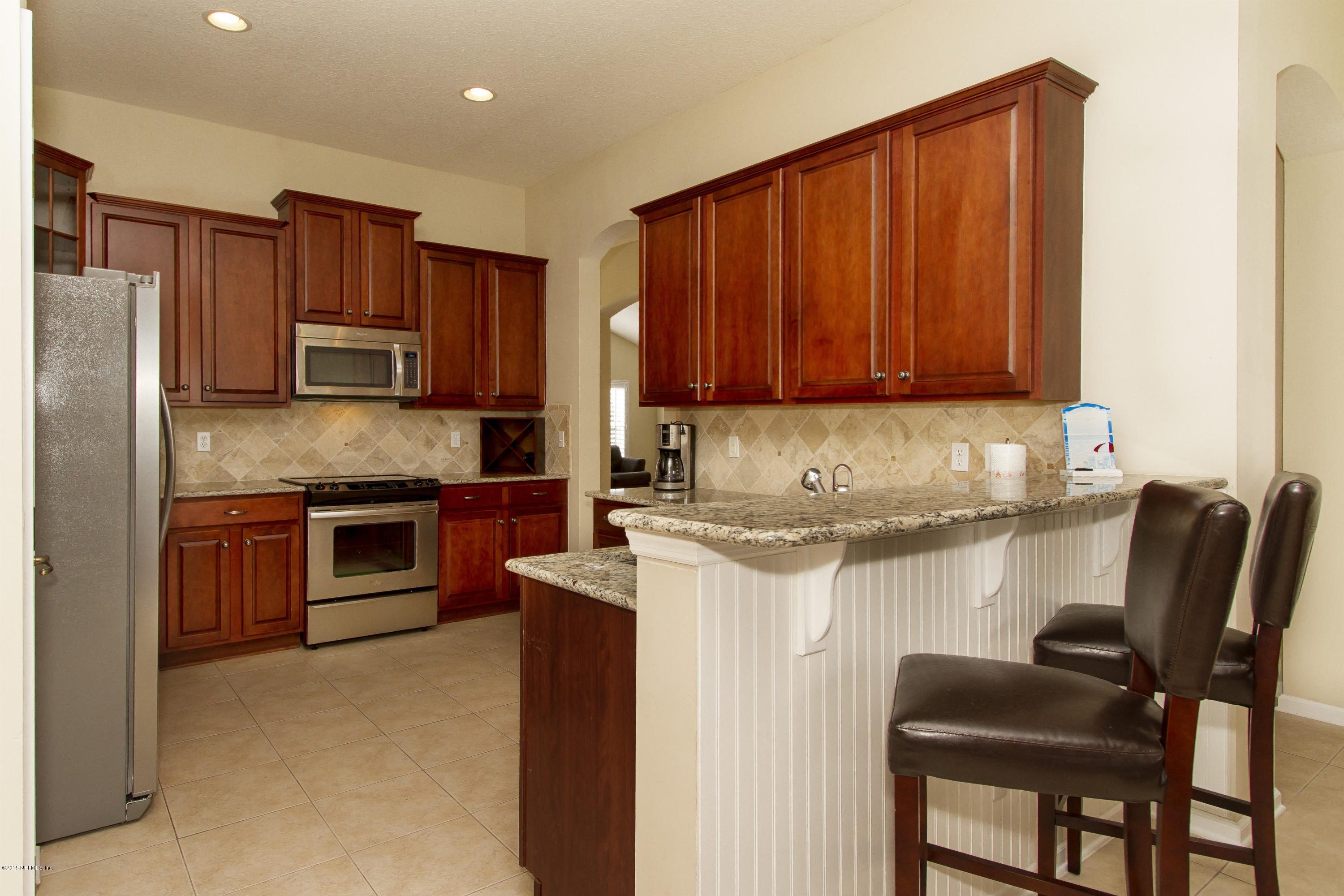 720 Porta Rosa Circle St. Augustine, FL 32092 - Photo 7 of 26 a kitchen with stainless steel appliances granite countertop a stove top oven a sink and a refrigerator