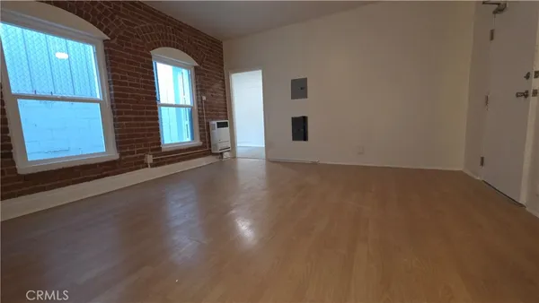a view of a livingroom with wooden floor and a window