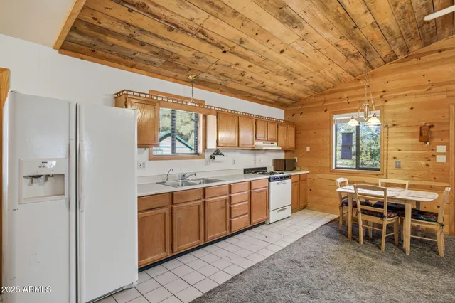 a large white kitchen with a large window and furniture