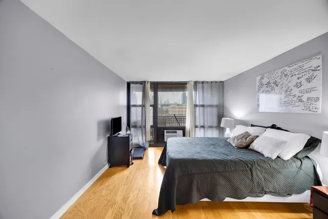 a bedroom with a bed and wooden floor