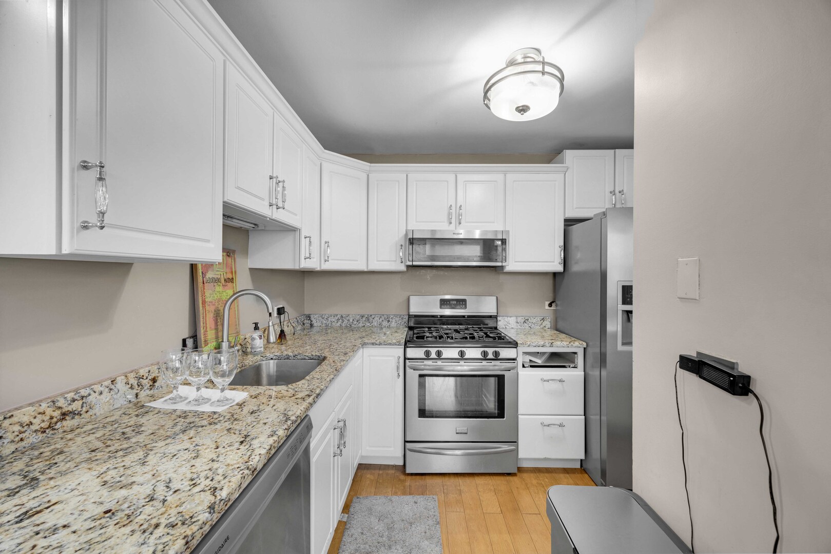 2605 South Indiana Avenue, Unit 403 Chicago, IL 60616 - Photo 3 of 16 a kitchen with granite countertop a stove a sink and a refrigerator