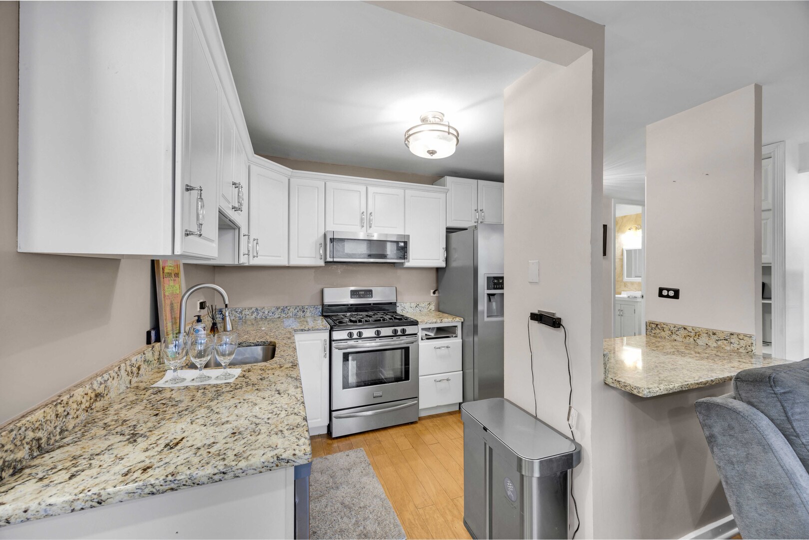 2605 South Indiana Avenue, Unit 403 Chicago, IL 60616 - Photo 4 of 16 a kitchen with stainless steel appliances granite countertop a stove a sink a refrigerator and a white cabinets