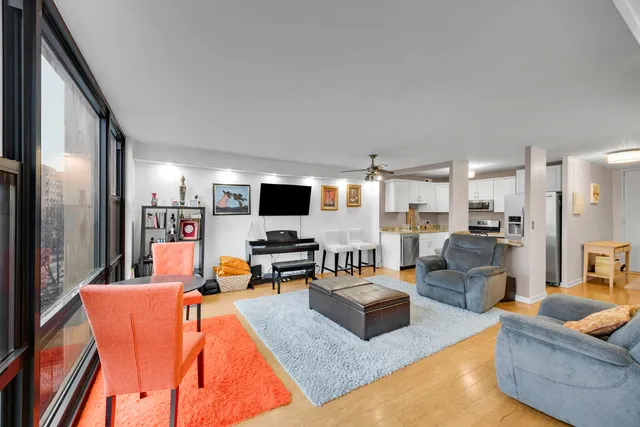 a living room with furniture kitchen view and a flat screen tv