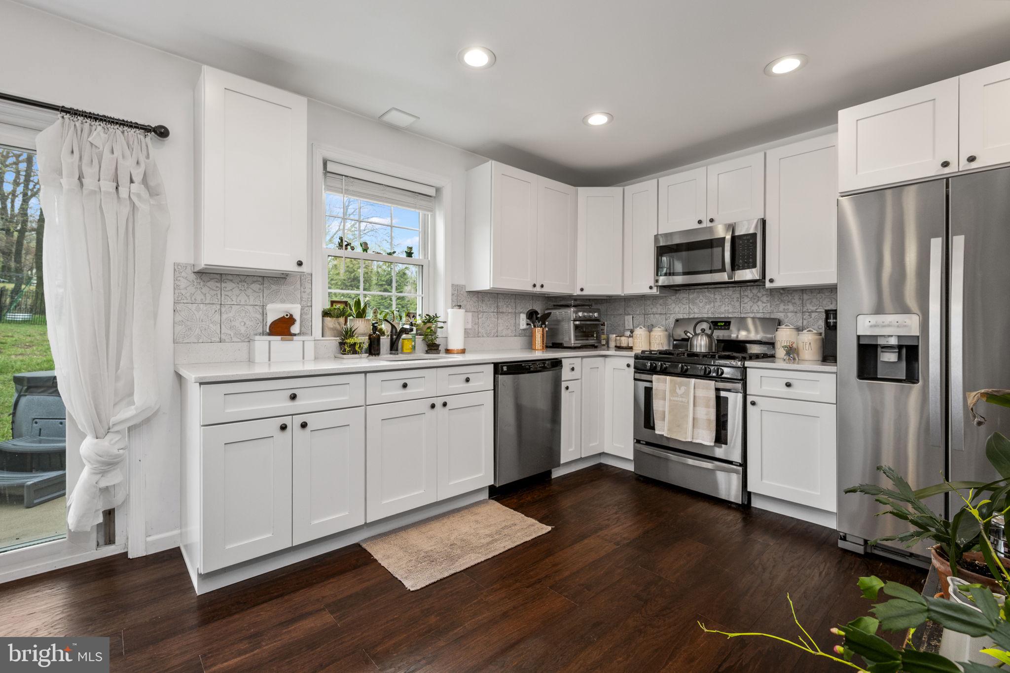 1915 Larkin Road Upper Chichester, PA 19061 - Photo 3 of 23 a kitchen with white cabinets white appliances a sink and a window