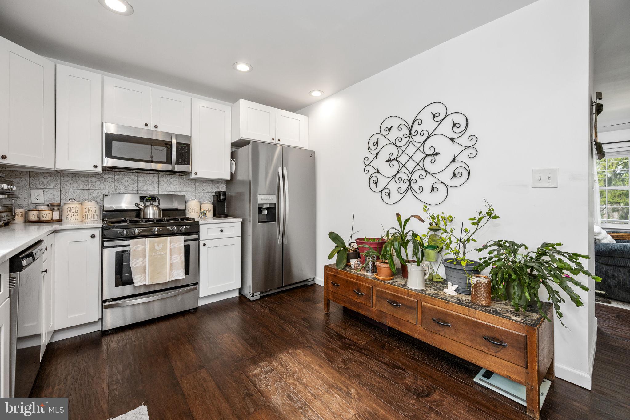 1915 Larkin Road Upper Chichester, PA 19061 - Photo 5 of 23 a kitchen with stainless steel appliances a refrigerator a sink and a stove with wooden floor