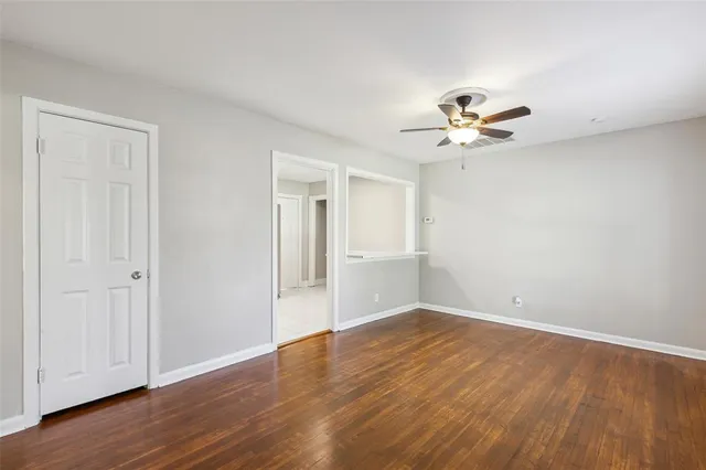 a view of a room with wooden floor and a ceiling fan