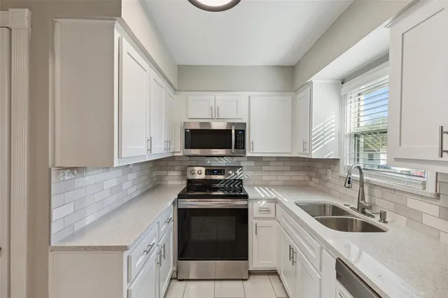 a kitchen with granite countertop a sink a stove a microwave and wooden cabinets