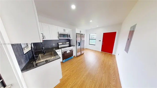 a kitchen with stainless steel appliances a refrigerator and a stove top oven