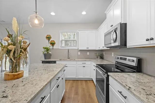 a kitchen that has a sink a stove and a wooden floor