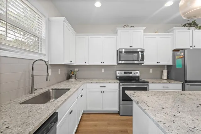 a kitchen with stainless steel appliances granite countertop a sink stove and refrigerator