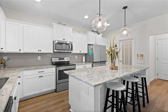 a kitchen with stainless steel appliances granite countertop a kitchen island a stove and a sink